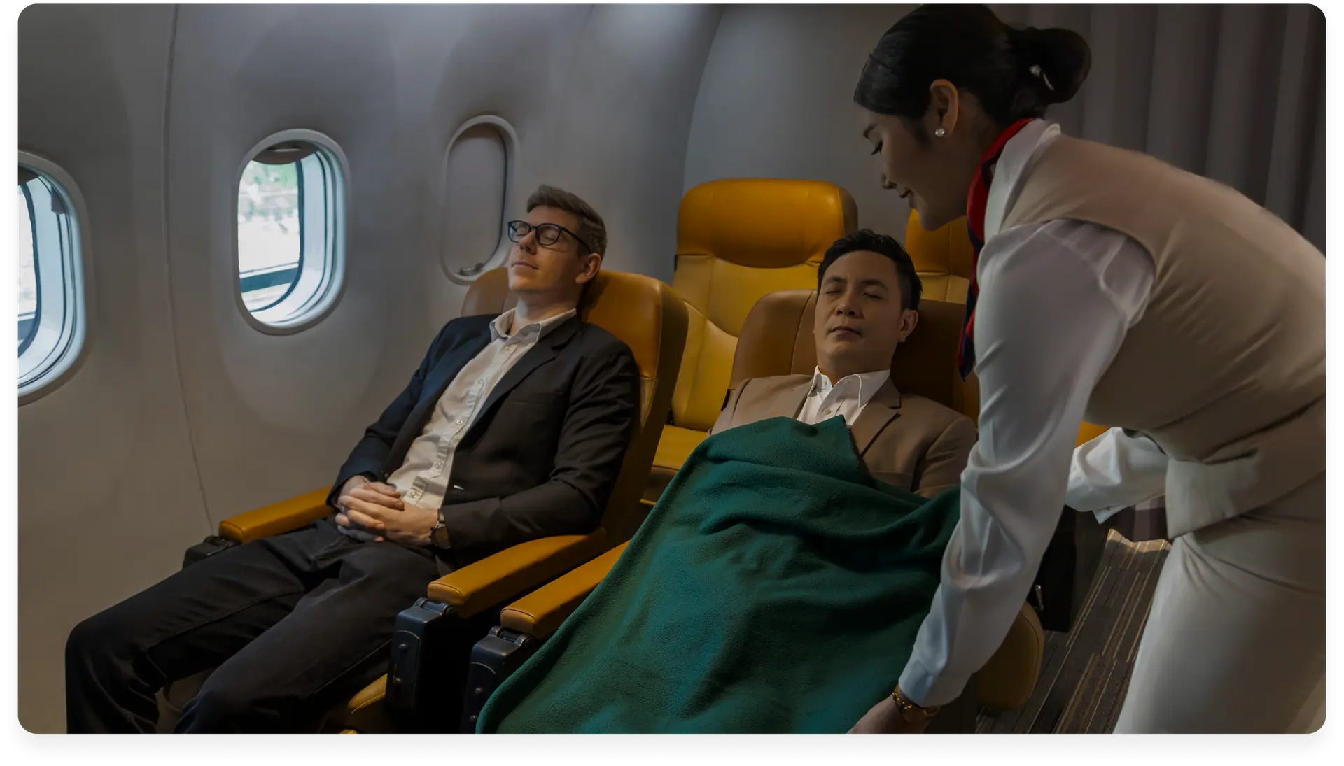 A cabin attendant serving passengers relaxing in a business class cabin
